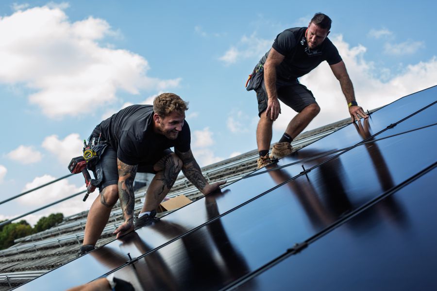 PowerHaus installers fitting all-black solar panels on a roof in Llantrisant