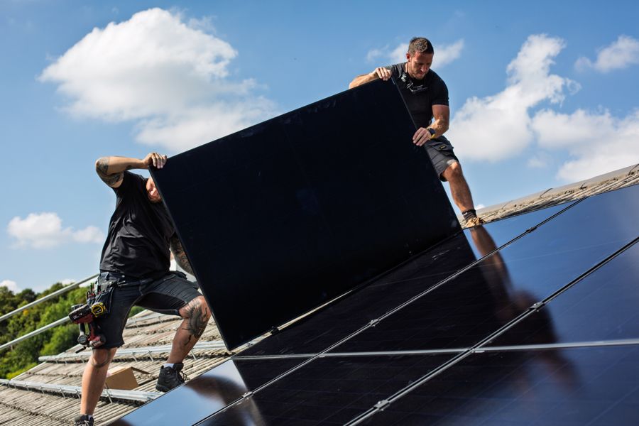 Carrying one of the last panels across the roof