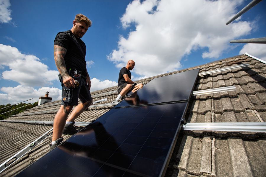 Installers on the roof with most of the panels now laid