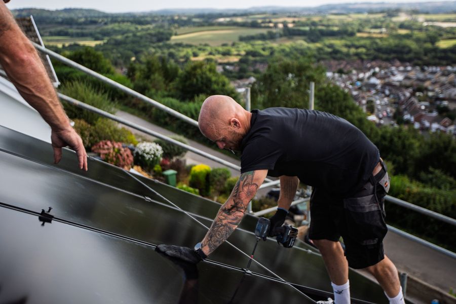 Working at the edge of the roof with the valley and houses behind
